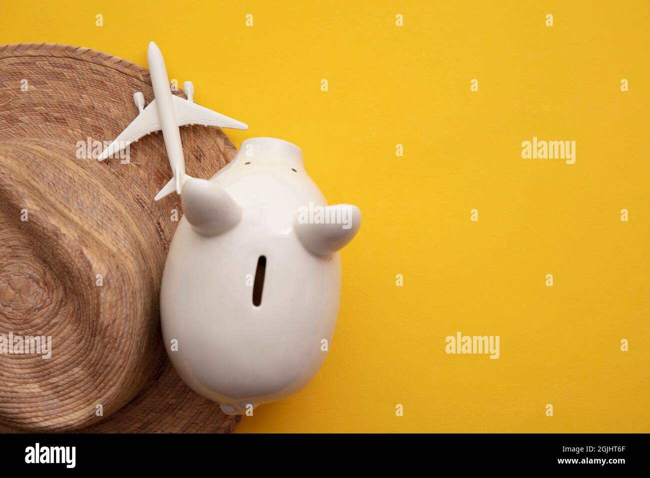 Saving for a summer vacation. Money piggy bank with holiday travel accessories Stock Photo