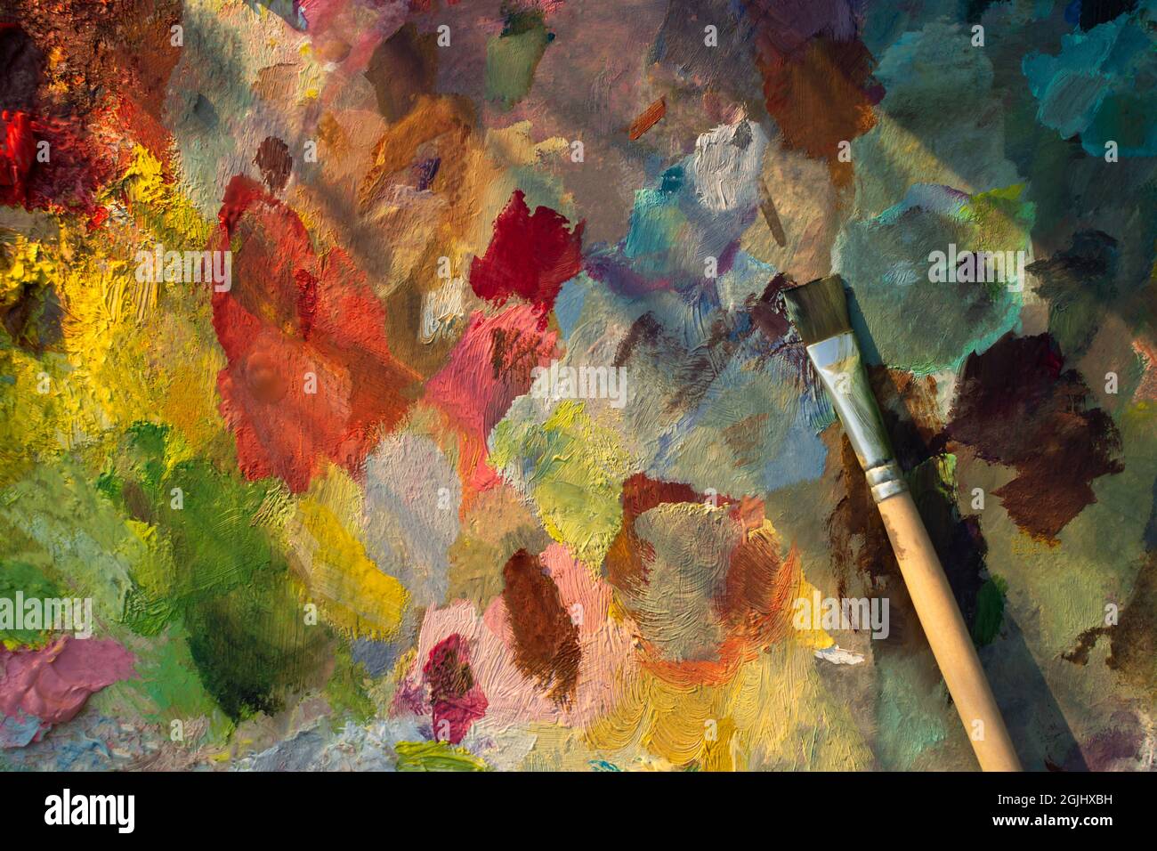 An artist's palette with an oil paint brush closeup. Blurry