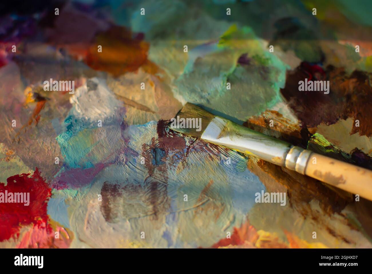An artist's palette with an oil paint brush closeup. Blurry