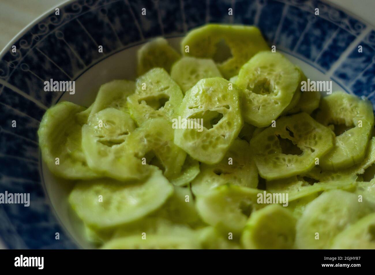 Close of sliced cucumbers on a plate Unusual cucumbers of funny shape looking like faces close view Stock Photo