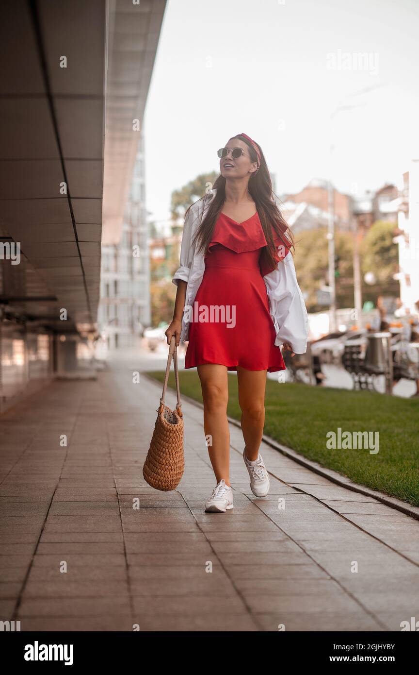 A stylish woman in a red dress in the street Stock Photo - Alamy