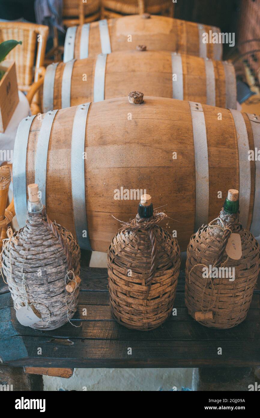 Old Wine Bottles and Wine Barrel in cellar Stock Photo