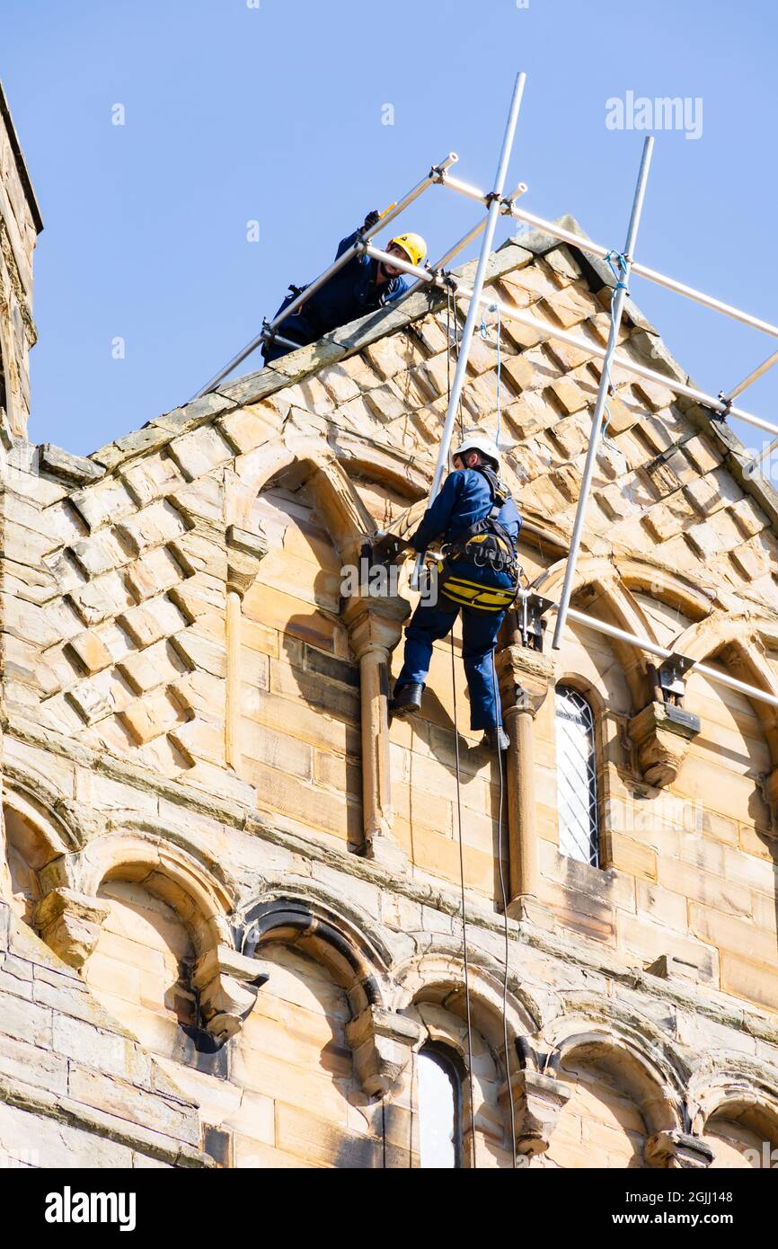 Workers dangle during repairs to Durham Cathedral, Durham, County Durham, England Stock Photo