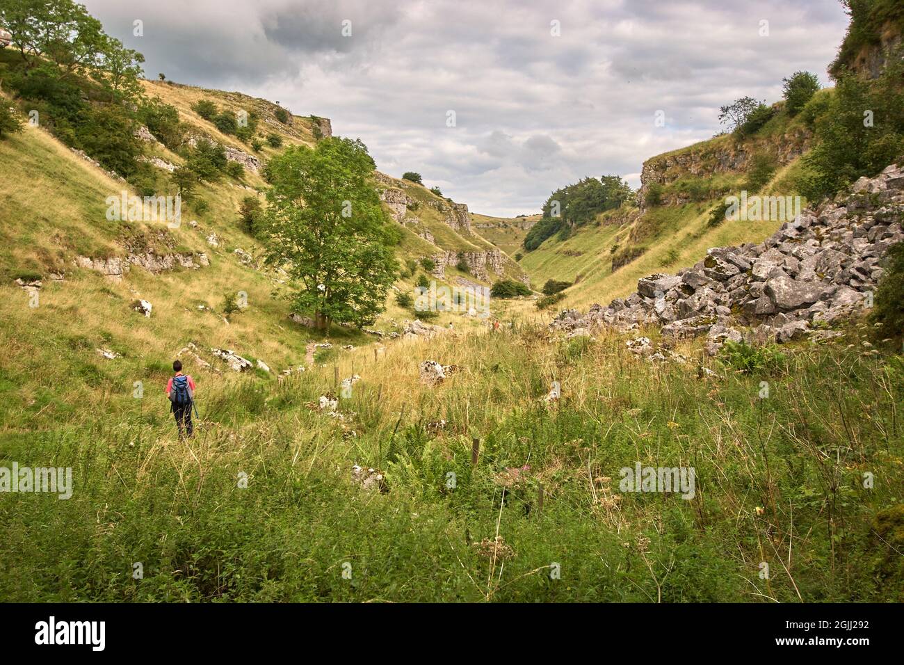 Walking in the upper reaches of Lathkill Dale in the Derbyshire Peak District UK Stock Photo