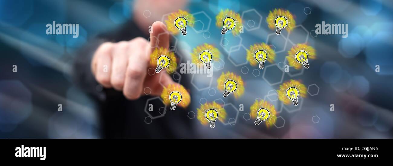 Man touching light bulbs on a touch screen with his finger Stock Photo