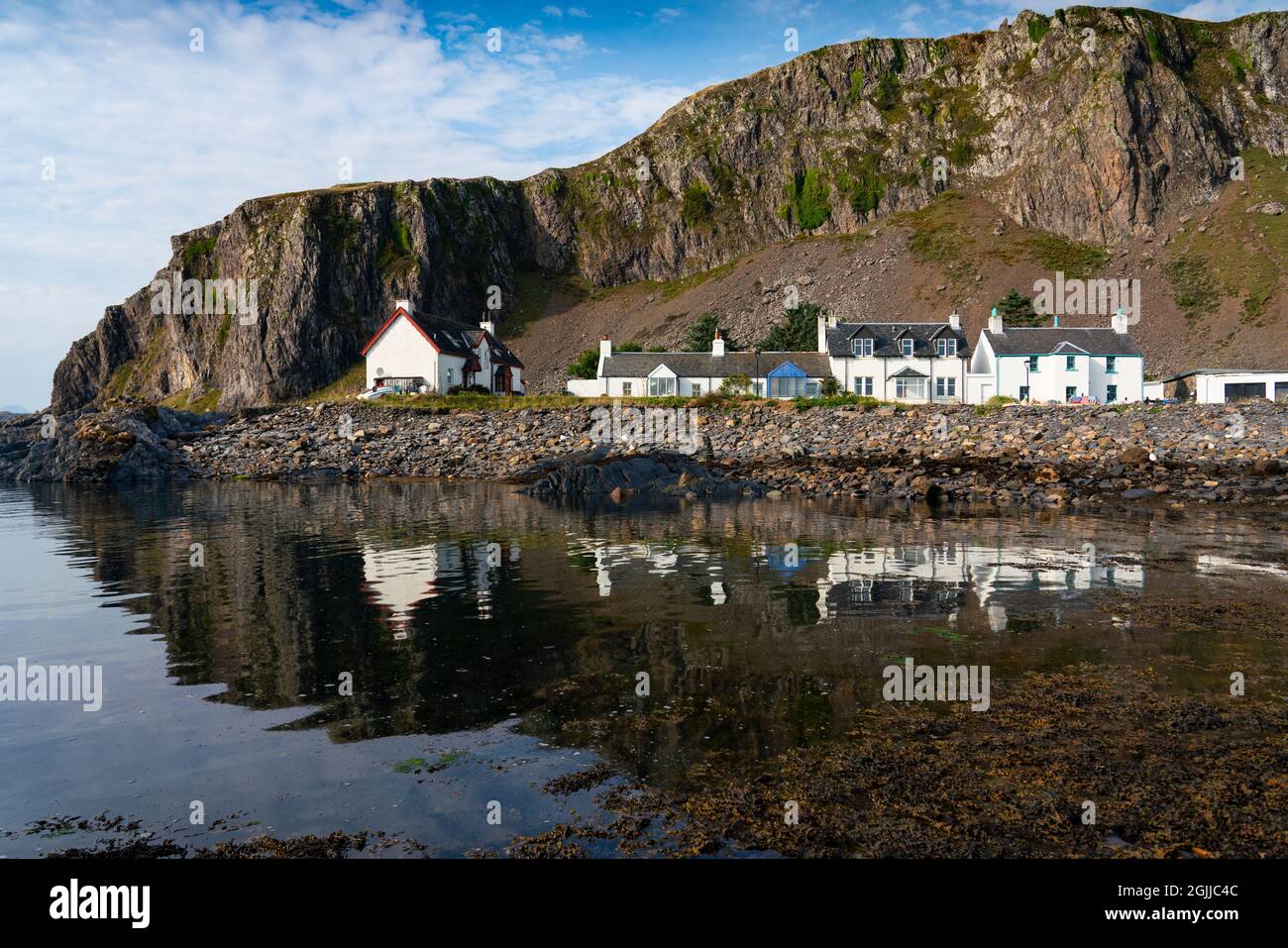 Row of whitewashed houses in harbour at Ellenabeich village at Easdale on Seil Island, one of the slate islands, Argyll and Bute, Scotland, UK Stock Photo