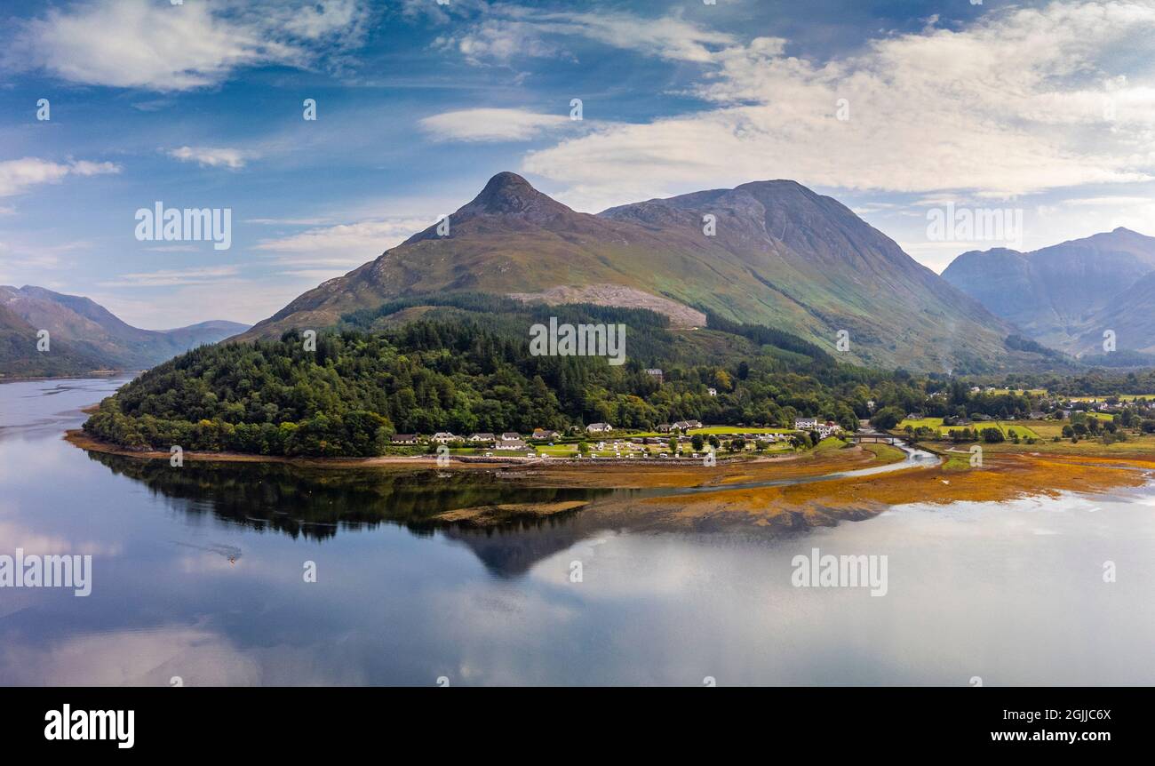 Aerial view from drone of Sgorr na Ciche or the Pap of Glencoe and village of Invercoe (left) and Glencoe village beside Loch Leven in Glen Coe , Loch Stock Photo