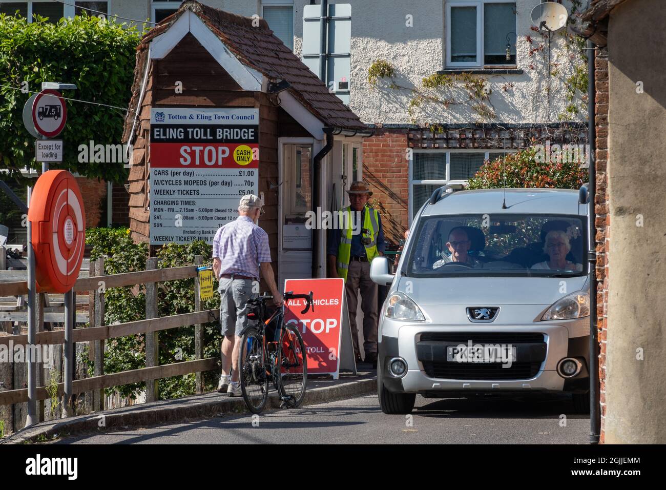 Eling toll bridge with couple in a car paying their money to cross, Hampshire, England, UK Stock Photo