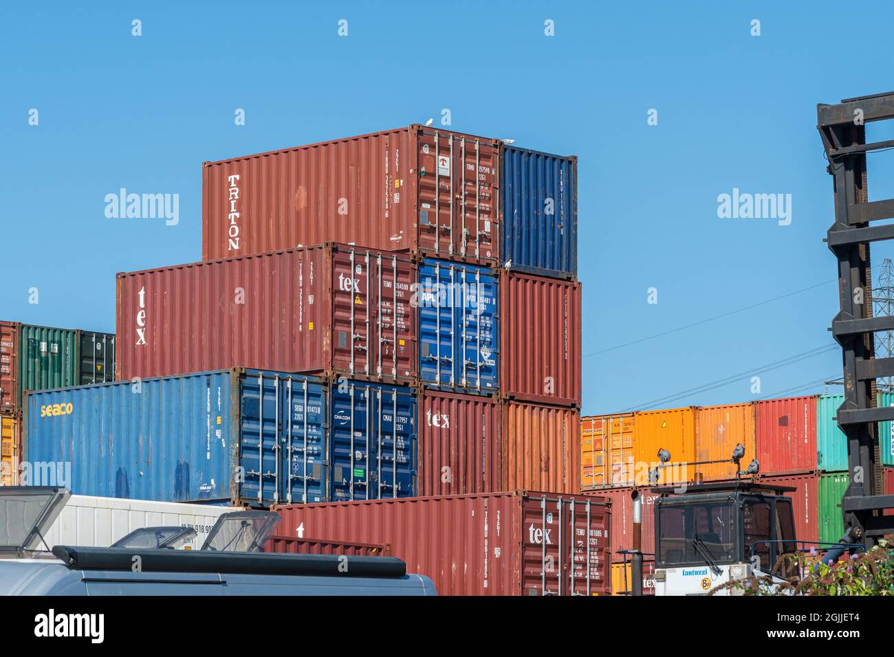 Shipping containers stacked up at Eling Wharf on Southampton Water, Hampshire, England, UK Stock Photo