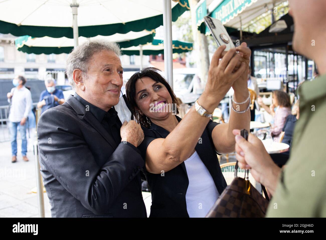 Tv presentator Michel Drucker take pictures with fan as he leaves after the  funeral ceremony for late French actor Jean-Paul Belmondo at the  Saint-Germain-des-Pres church in Paris on September 10, 2021. Several