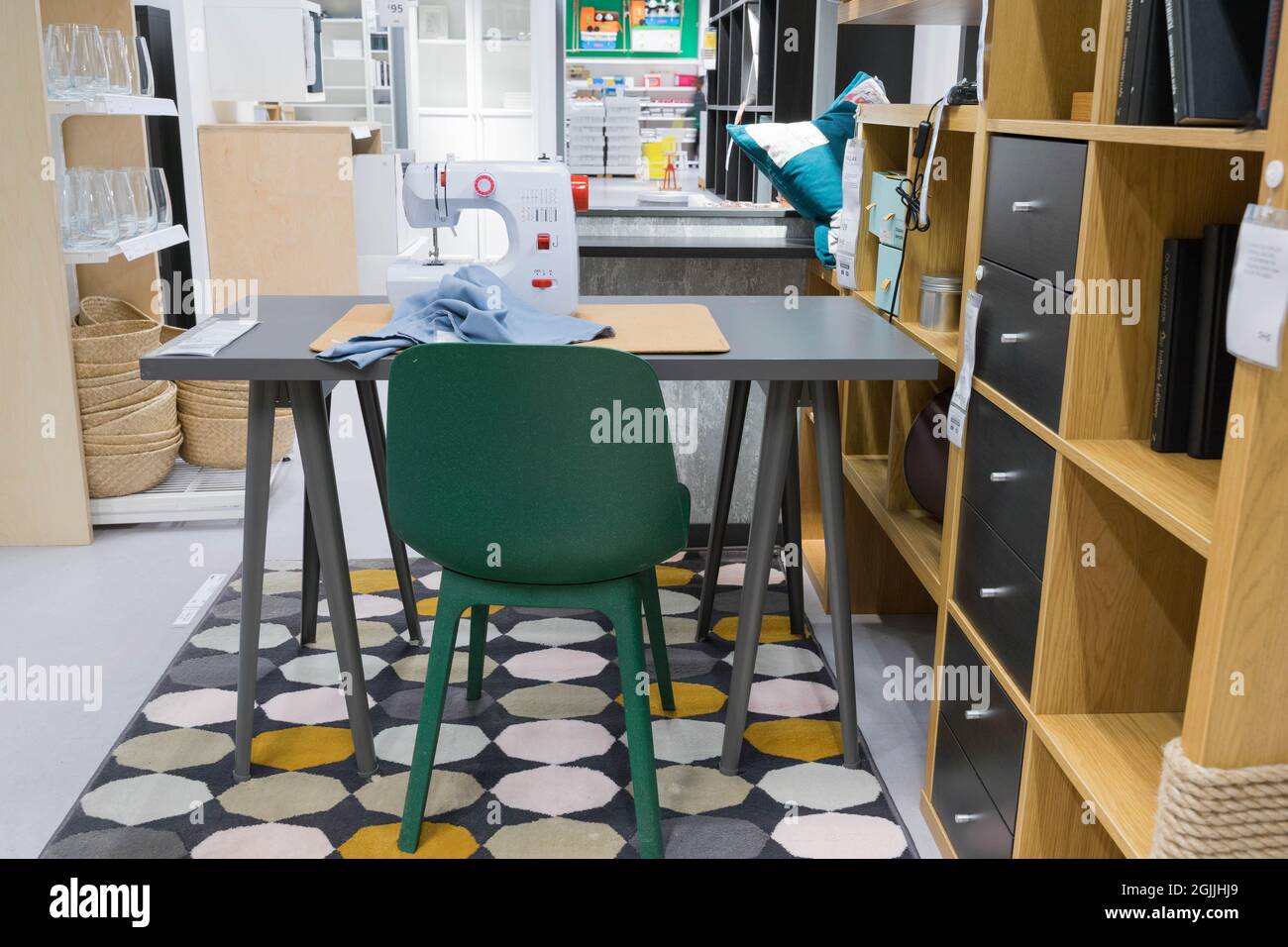 Worktop installed with sewing machine, chair and shelving units Stock