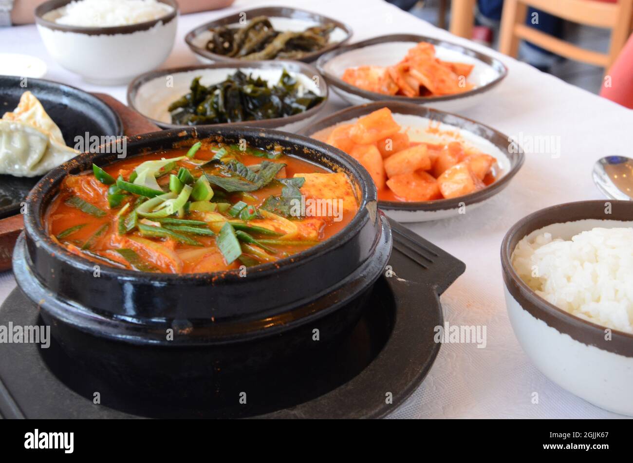 https://c8.alamy.com/comp/2GJJK67/korean-signature-kimchi-stew-in-a-hot-ceramic-pot-served-with-other-side-dishes-2GJJK67.jpg