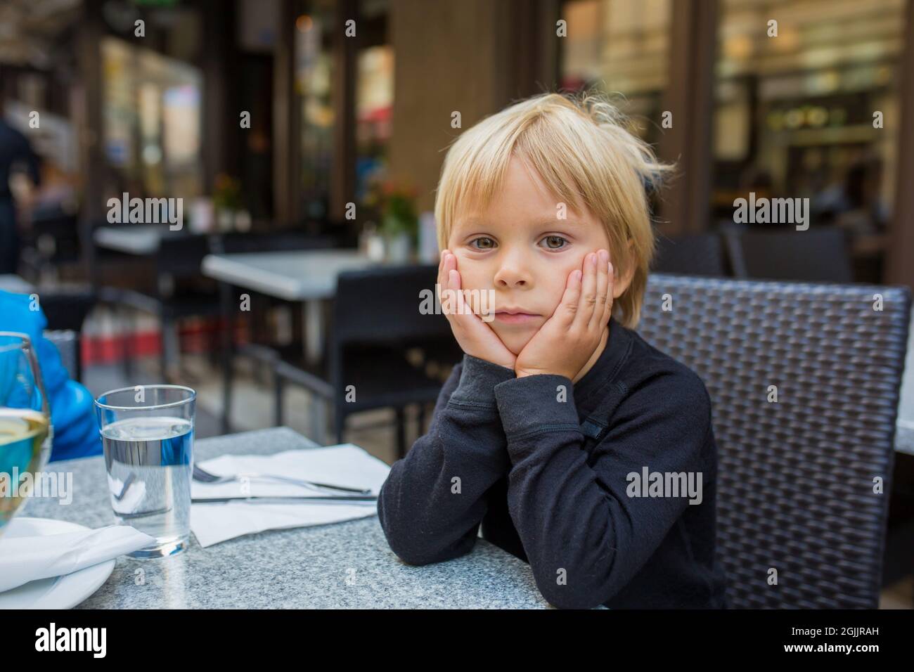 Preschool child, cute boy, eating fish and chips a restaurant, cozy atmosphere, local small restaurant in Stockholm, Sweden Stock Photo