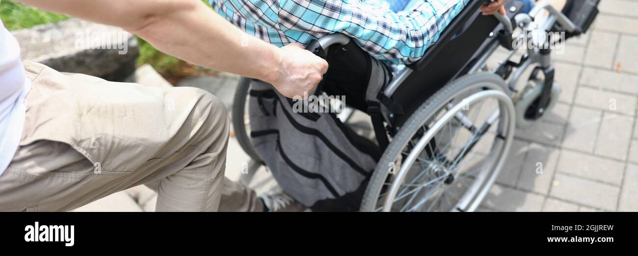Man lifts a woman in wheelchair up stairs Stock Photo Alamy