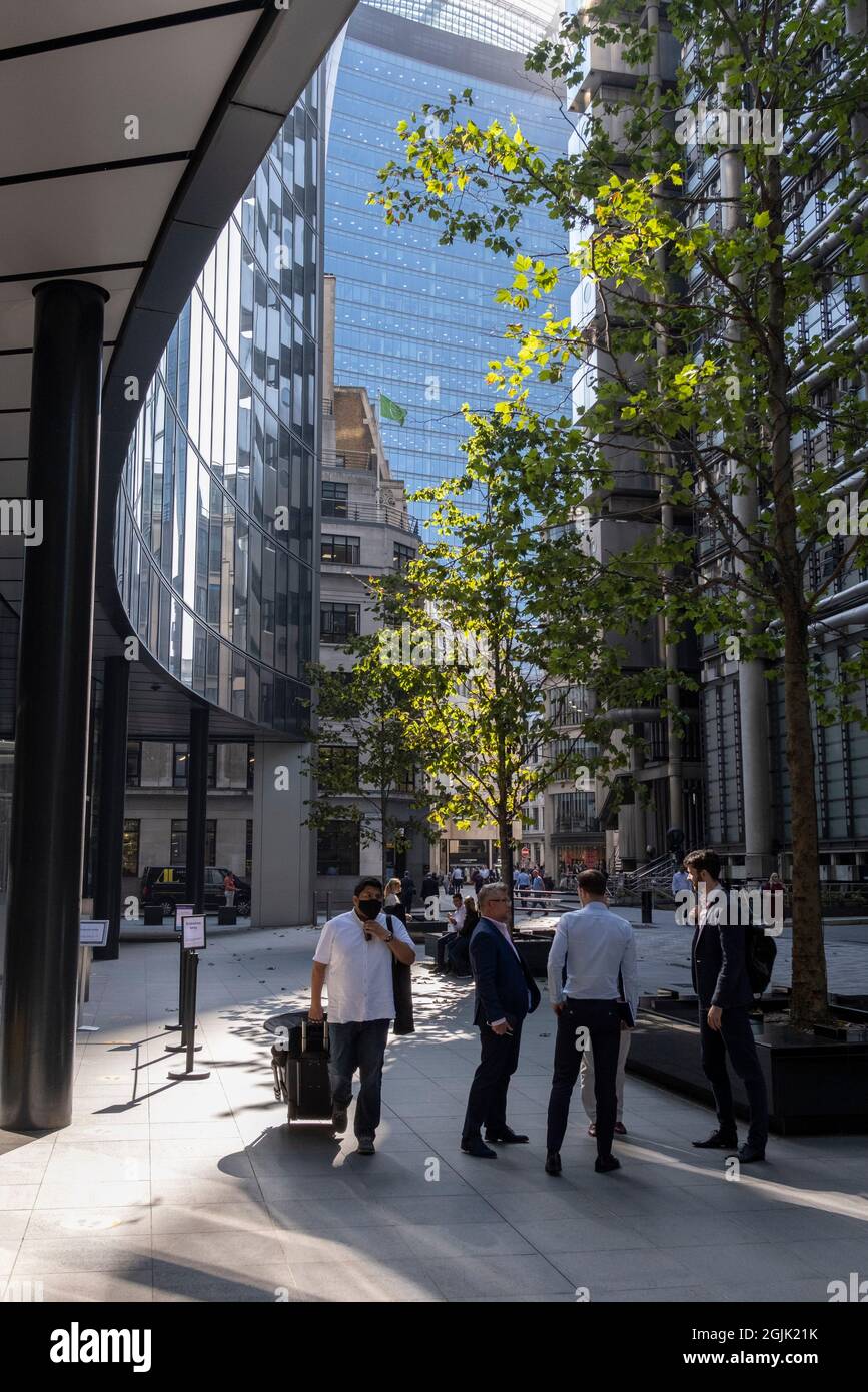 In the week that many more Londoners returned to their office workplaces after the Covid pandemic, workers sit and walk through September sunshine on Lime Street in the City of London, the capital's financial district, on 8th September 2021, in London, England. Stock Photo