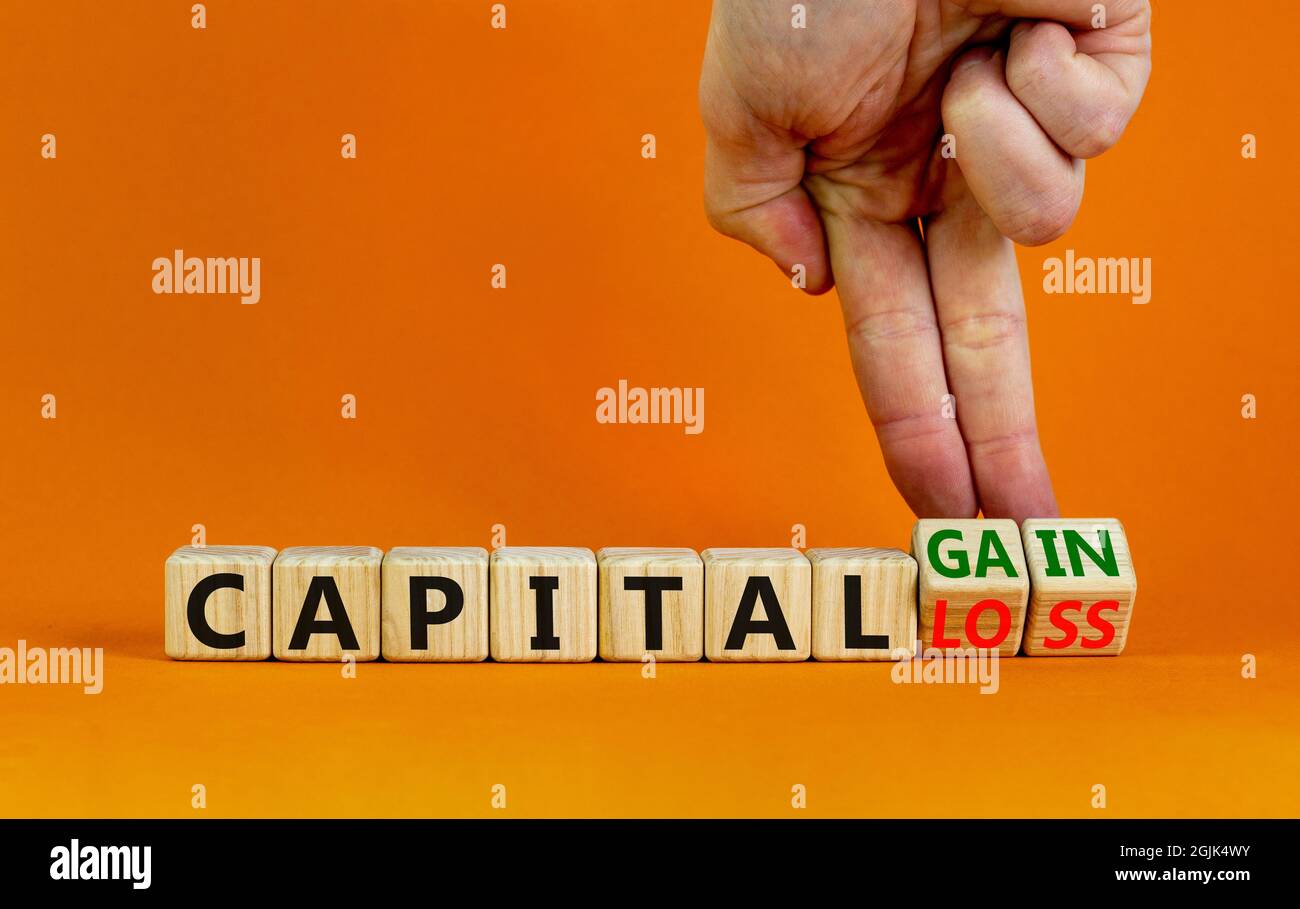 Capital loss or gain symbol. Businessman turns cubes and changes words