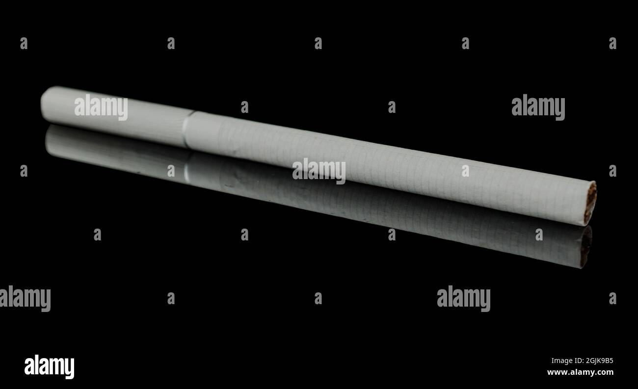 One thin cigarette on a black background, with reflection Stock Photo