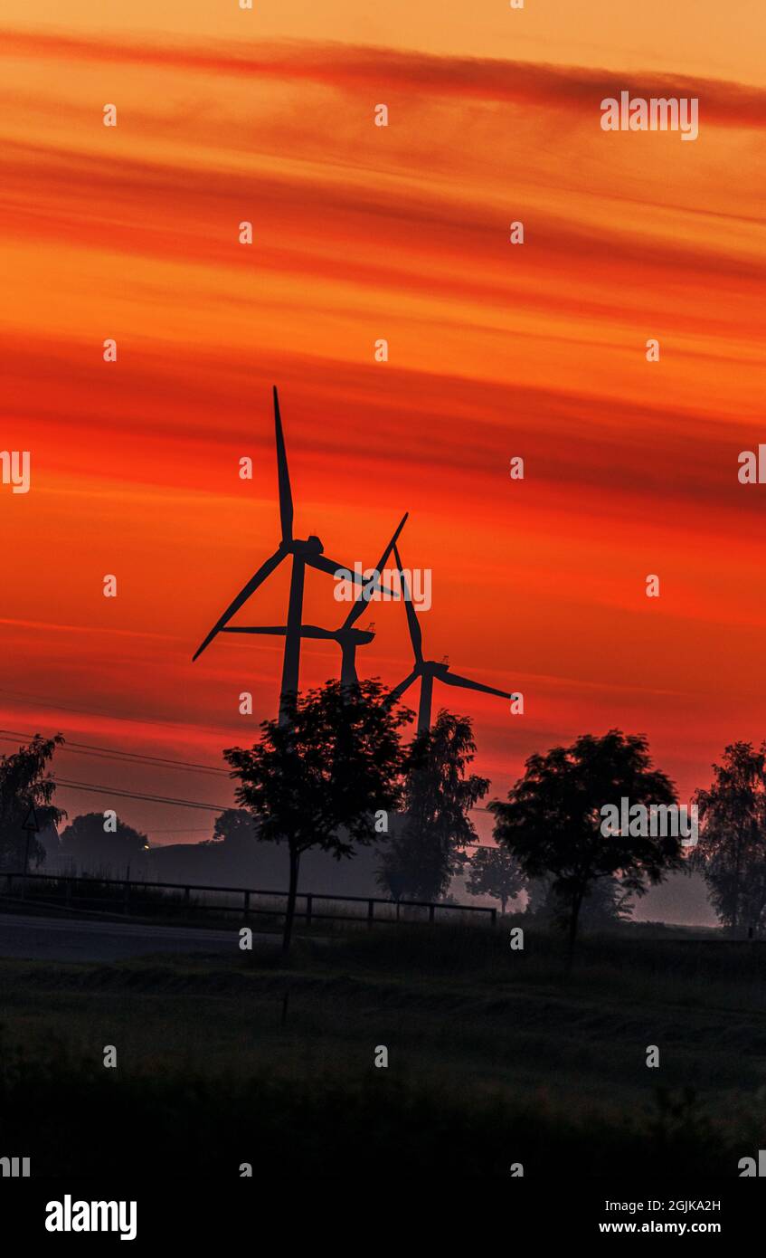 Silhouette of wind turbines during the orange sunset Stock Photo - Alamy