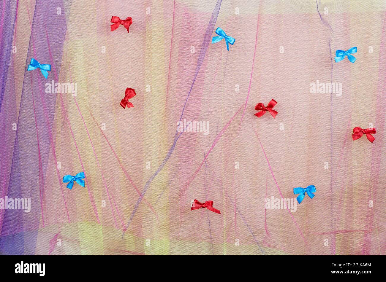 Background from multicolored tulle with red and blue bows Stock Photo