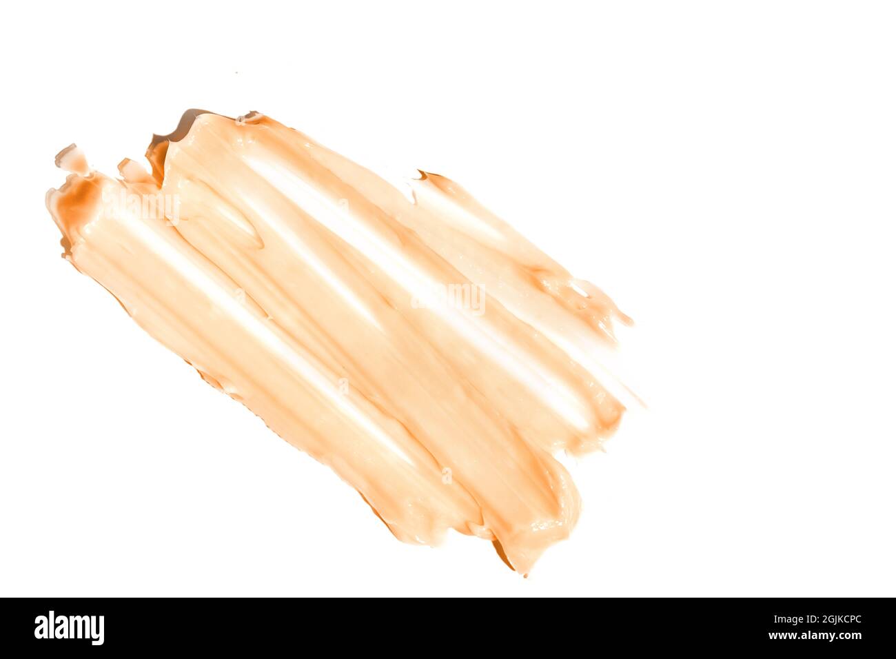 The smear and texture of the foundation. Peach color isolated on a white background. An element for cosmetic beauty design. High quality photo Stock Photo
