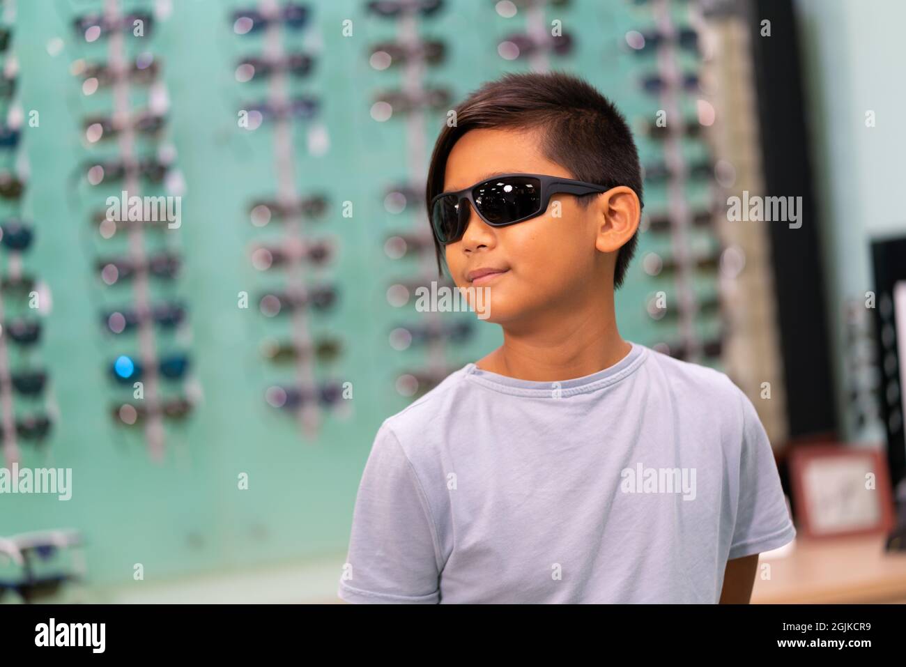 An Asian boy wearing sunglasses in a glasses store Stock Photo