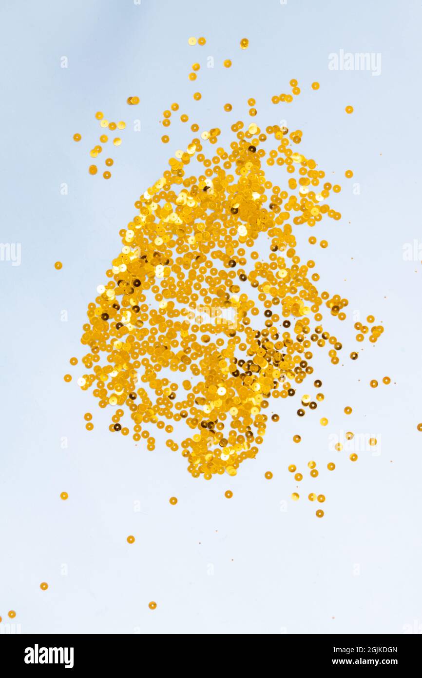 Light blue background with golden confetti, selective focus Stock Photo