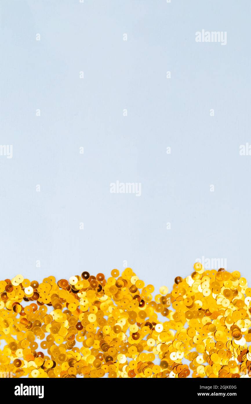 Light blue background with golden confetti, selective focus Stock Photo
