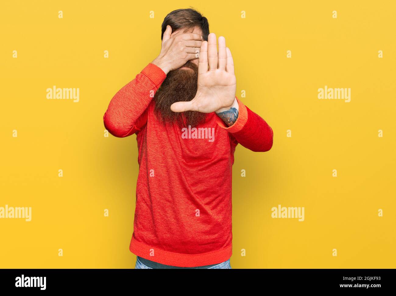 Redhead man with long beard wearing casual clothes covering eyes with hands and doing stop gesture with sad and fear expression. embarrassed and negat Stock Photo