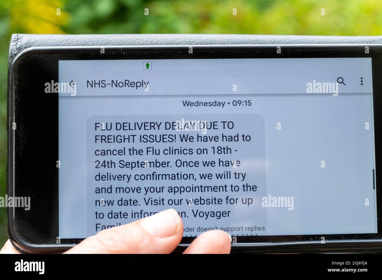 Flu jab clinic cancellation text message on mobile phone, UK, September 2021. Cancelled vaccinations due to freight delivery delays. Stock Photo