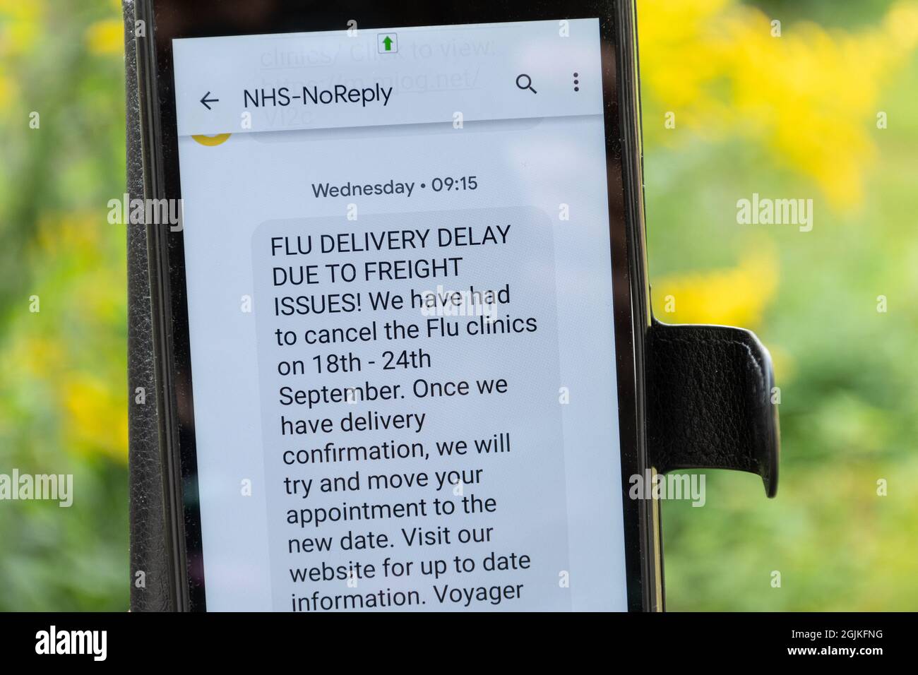 Flu jab clinic cancellation text message on mobile phone, UK, September 2021. Cancelled vaccinations due to freight delivery delays. Stock Photo