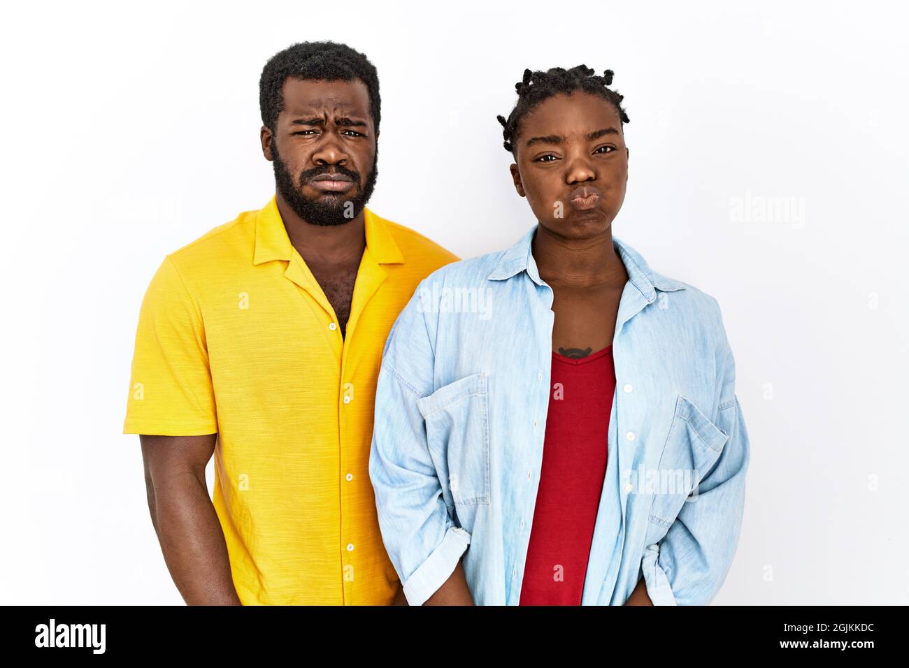 Young african american couple wearing casual clothes puffing cheeks ...