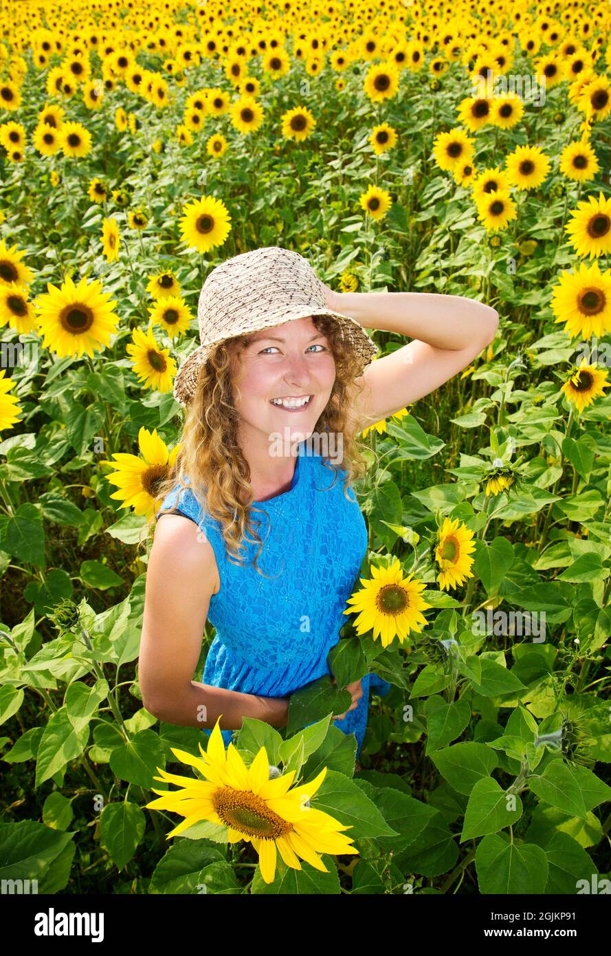 Girl in a sunflower field wearing blue dress Stock Photo - Alamy