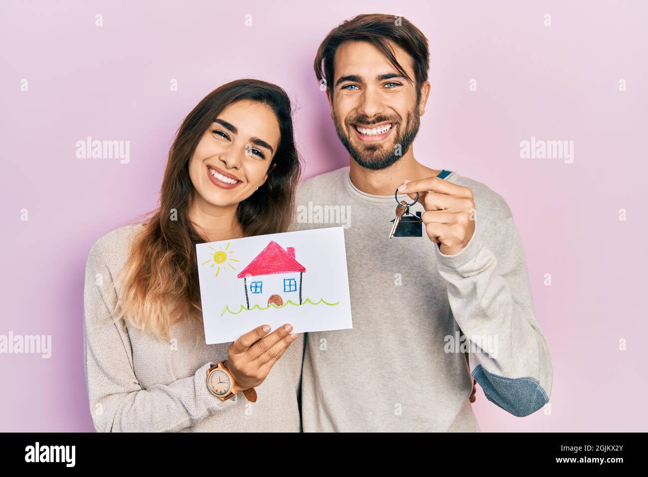 Young hispanic couple holding house draw and key of new home smiling ...