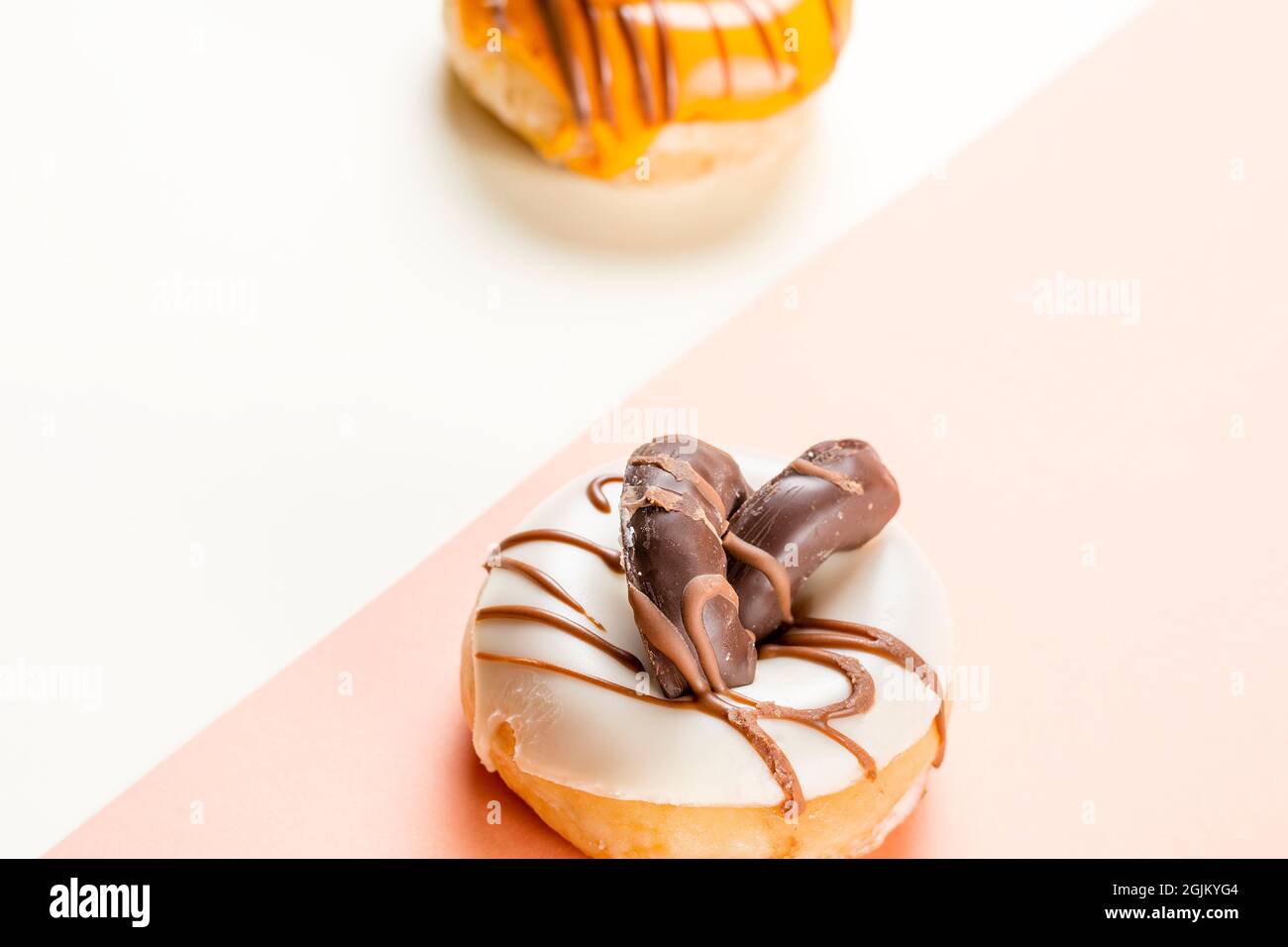 Close-up of a white donuts with chocolate chip cookies and a side of unfocused cream donuts.The photograph is taken in horizontal format and has a two Stock Photo