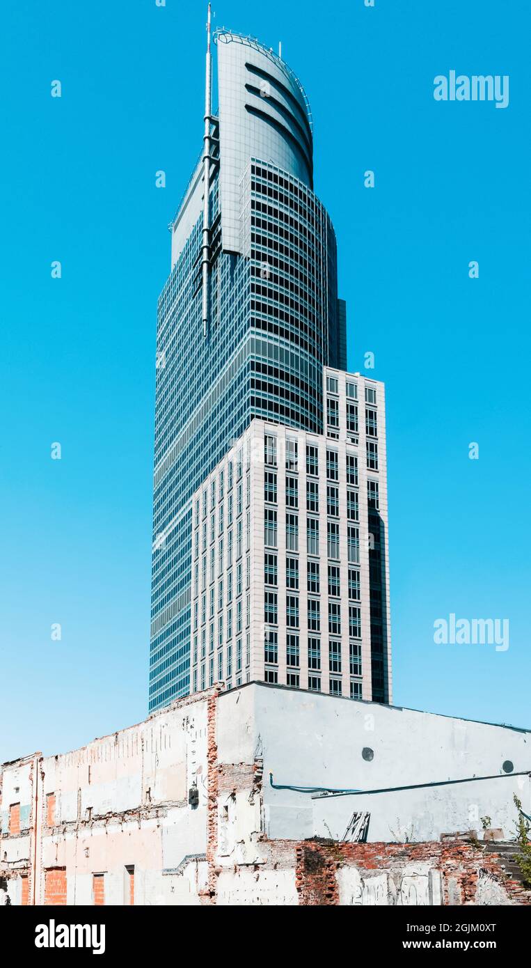 Warsaw, Poland - April 26th, 2021: UNIQA/AXA insurance company modern skyscaper near old building in Warsaw, Poland Stock Photo