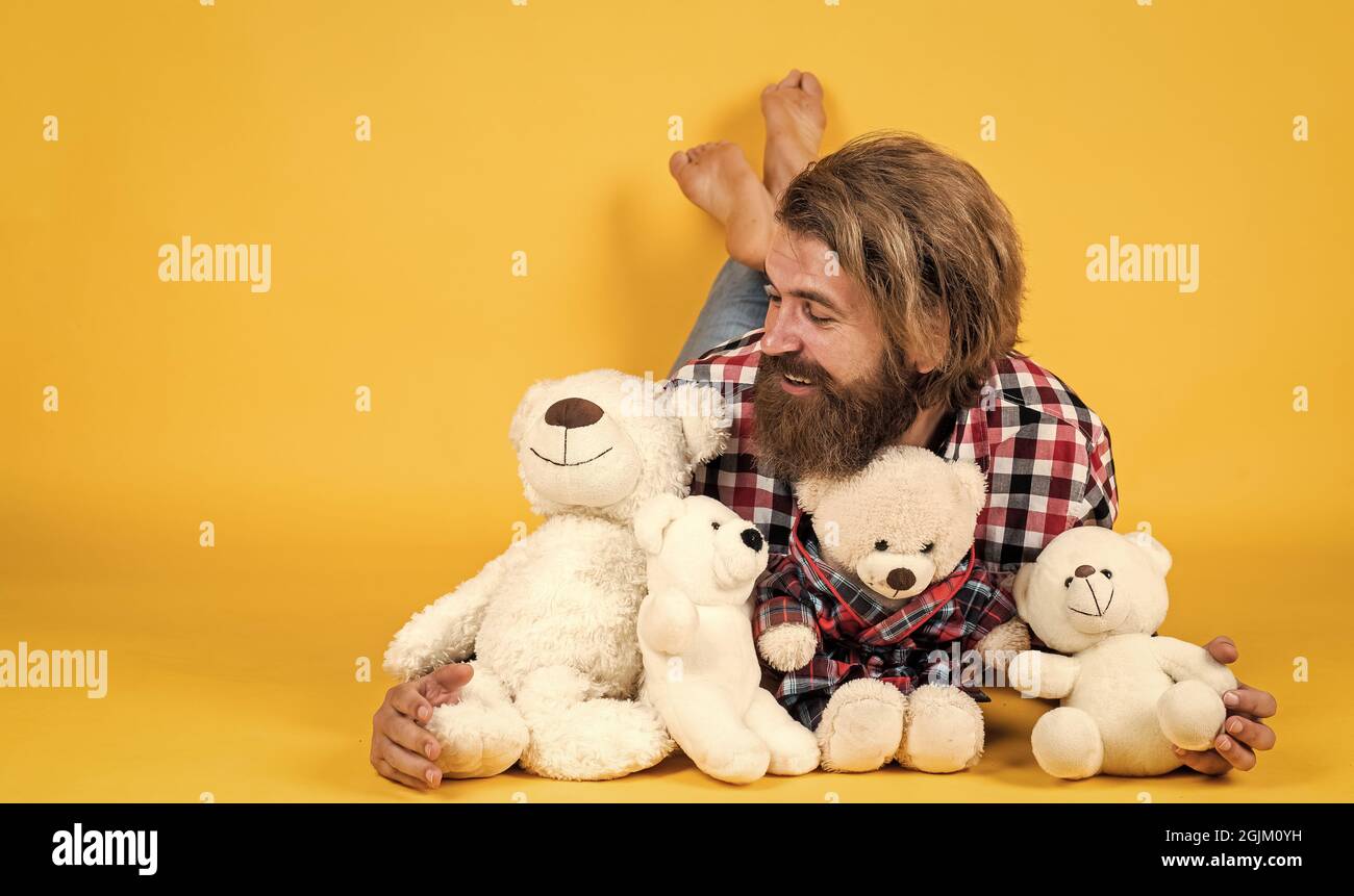 being in good mood. happy valentines day. cheerful bearded man hold teddy bear. male feel playful with bear. brutal mature hipster man play with toy Stock Photo