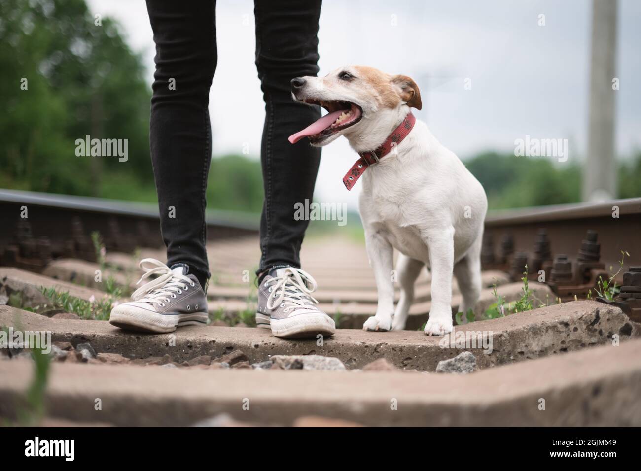 Hipster man in black jeans pants and grey sneakers on railway Stock Photo