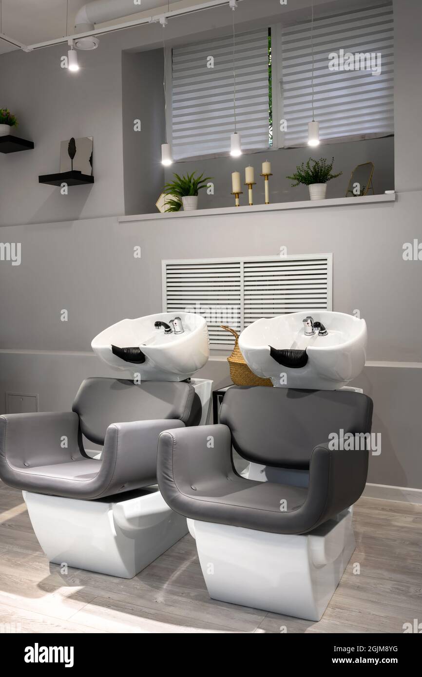 Hair salon interior, modern beauty store after renovation. Inside empty barber shop with mirrors and leather chairs. Clean trendy hairdressing salon w Stock Photo