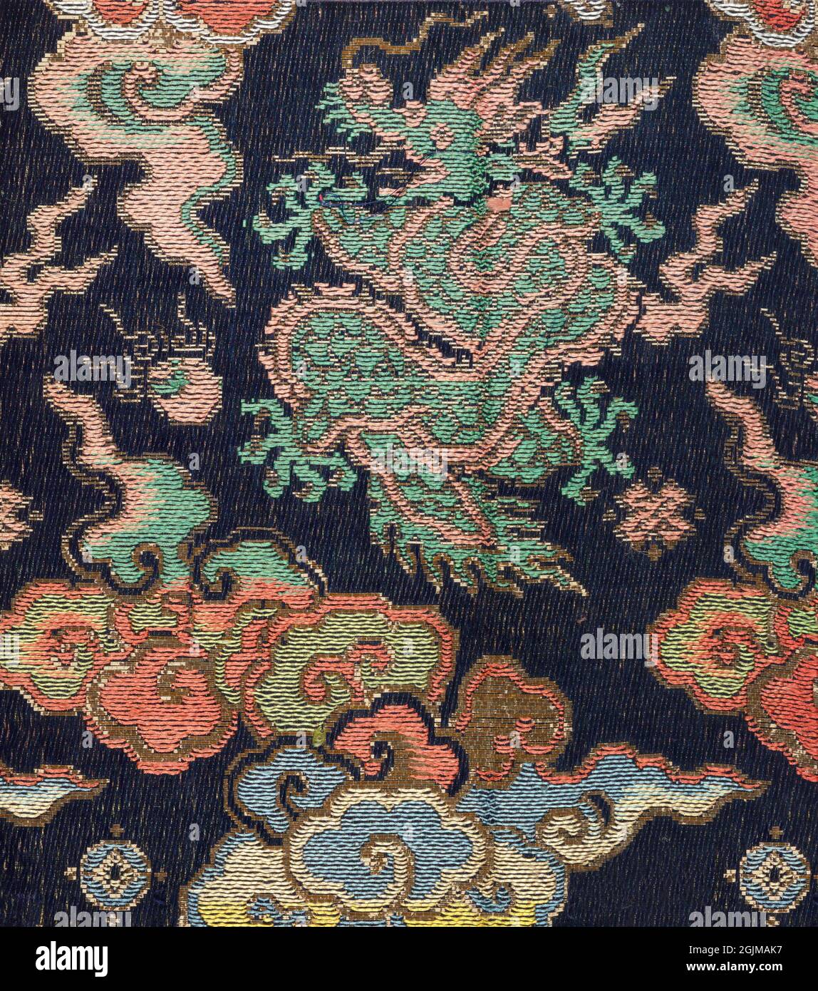 Brocaded Japanese textile depicting dragon and clouds, executed in sik and metallic threads on an indigo ground. Japan Stock Photo