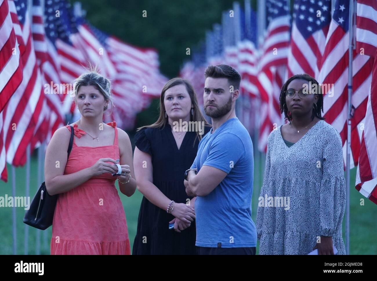 St. Louis, USA. 10th Sep, 2021. Visitors to the Flags of Valor on Art Hill, listen as the names of those killed at the World Trade Centers, and the servicemen and women who have been killed in war since the 9/11 attacks are read at dusk on Friday, September 10, 2021. The are 7400 American flags on display to honor their memory. Photo by Bill Greenblatt/UPI Credit: UPI/Alamy Live News Stock Photo