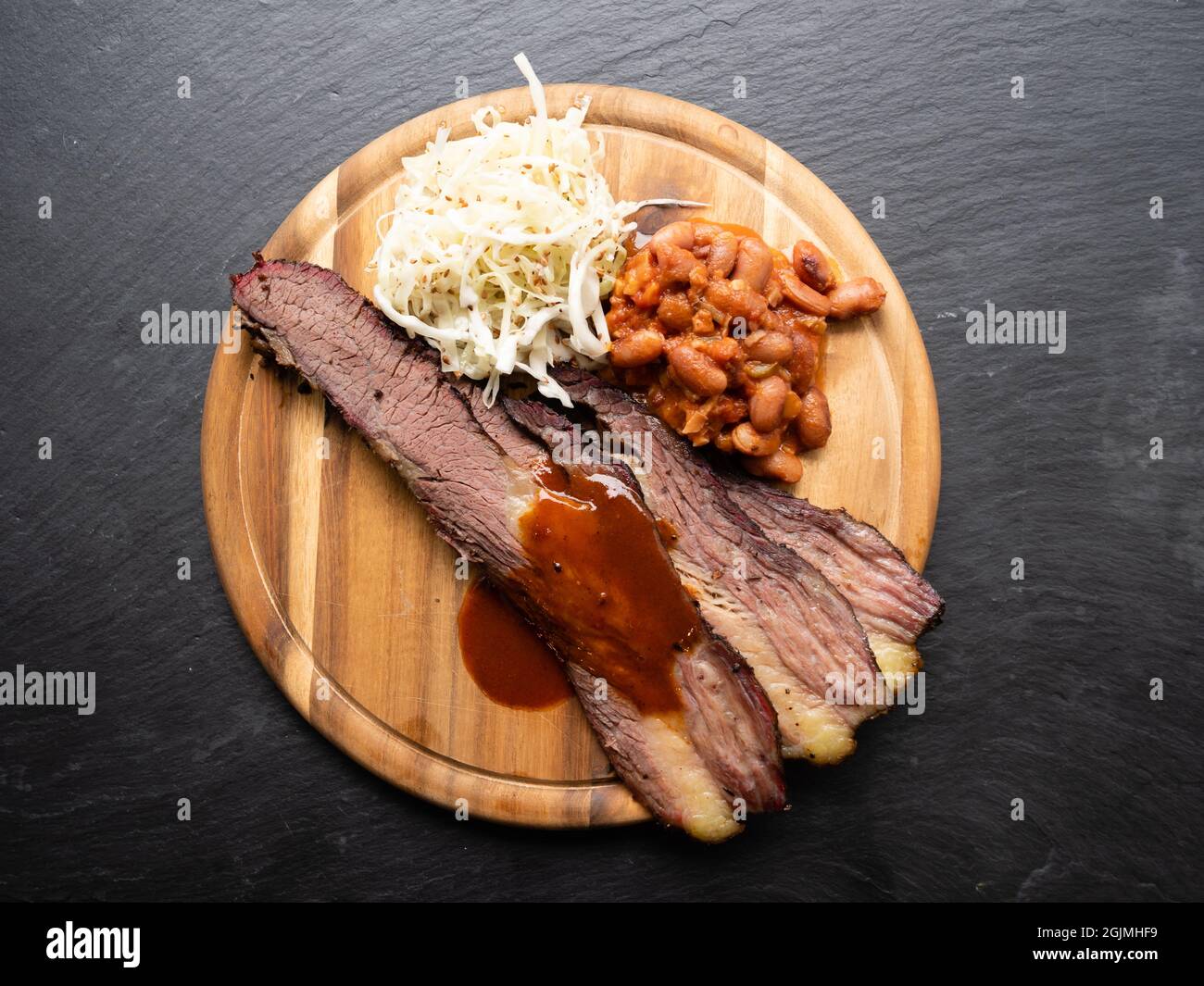 BBQ Brisket in Texas Style with Pinto Beans, Coleslaw and Red Sauce Top View Stock Photo