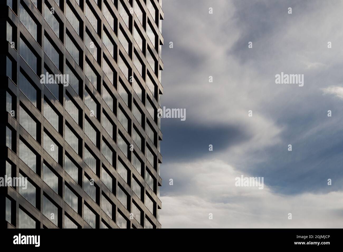 A generic image of an office building reflecting a cloudy sky in its ...