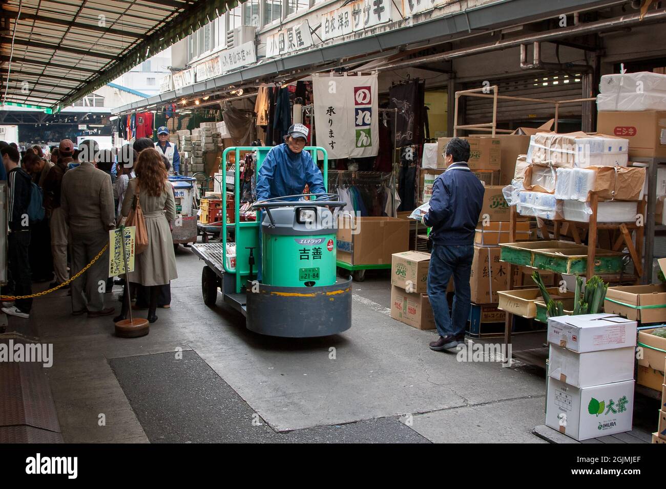 Shops, shoppers, tourists and electric carts in the streets of Tsukiji outer market. Tsukiji, Tokyo, Japan. Stock Photo