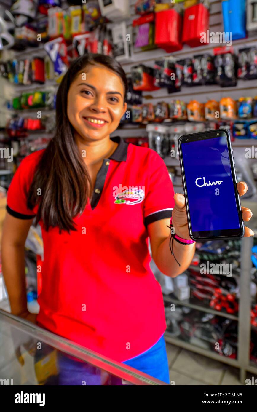 A worker shows the Chivo Wallet app on her phone during the Cryptocurrency  legal tender.The Echeveria Importer business, where motorcycle repair parts  are sold has decided to register as a business in
