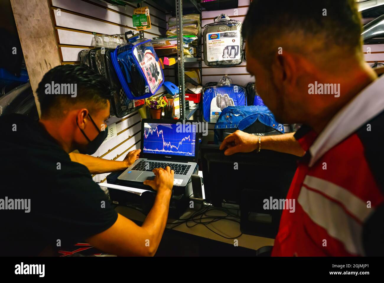 Workers check the price of Bitcoin on a laptop during the Cryptocurrency  legal tender.The Echeveria Importer business, where motorcycle repair parts  are sold has decided to register as a business in the