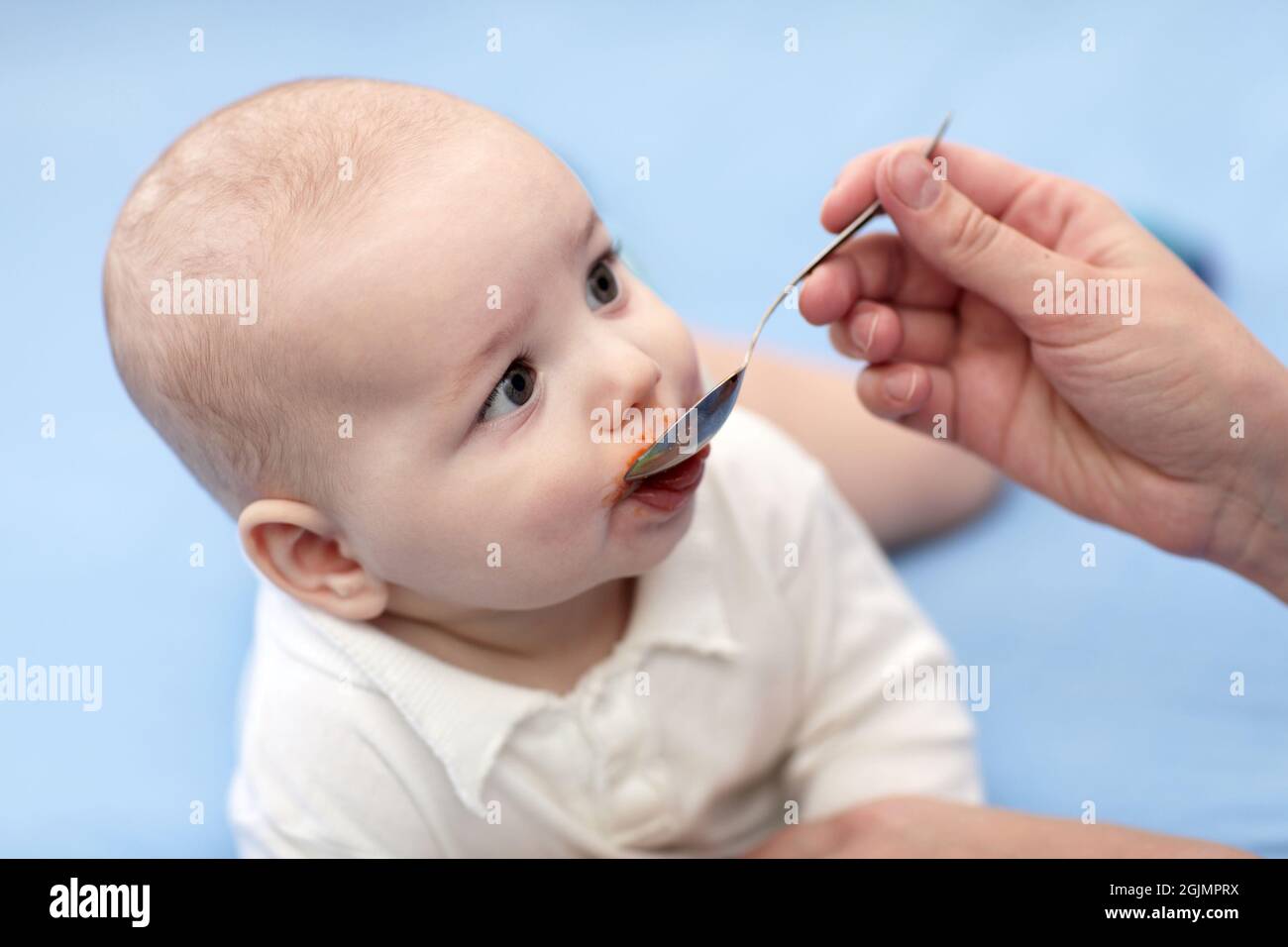 Mother gives remedy to her baby boy Stock Photo