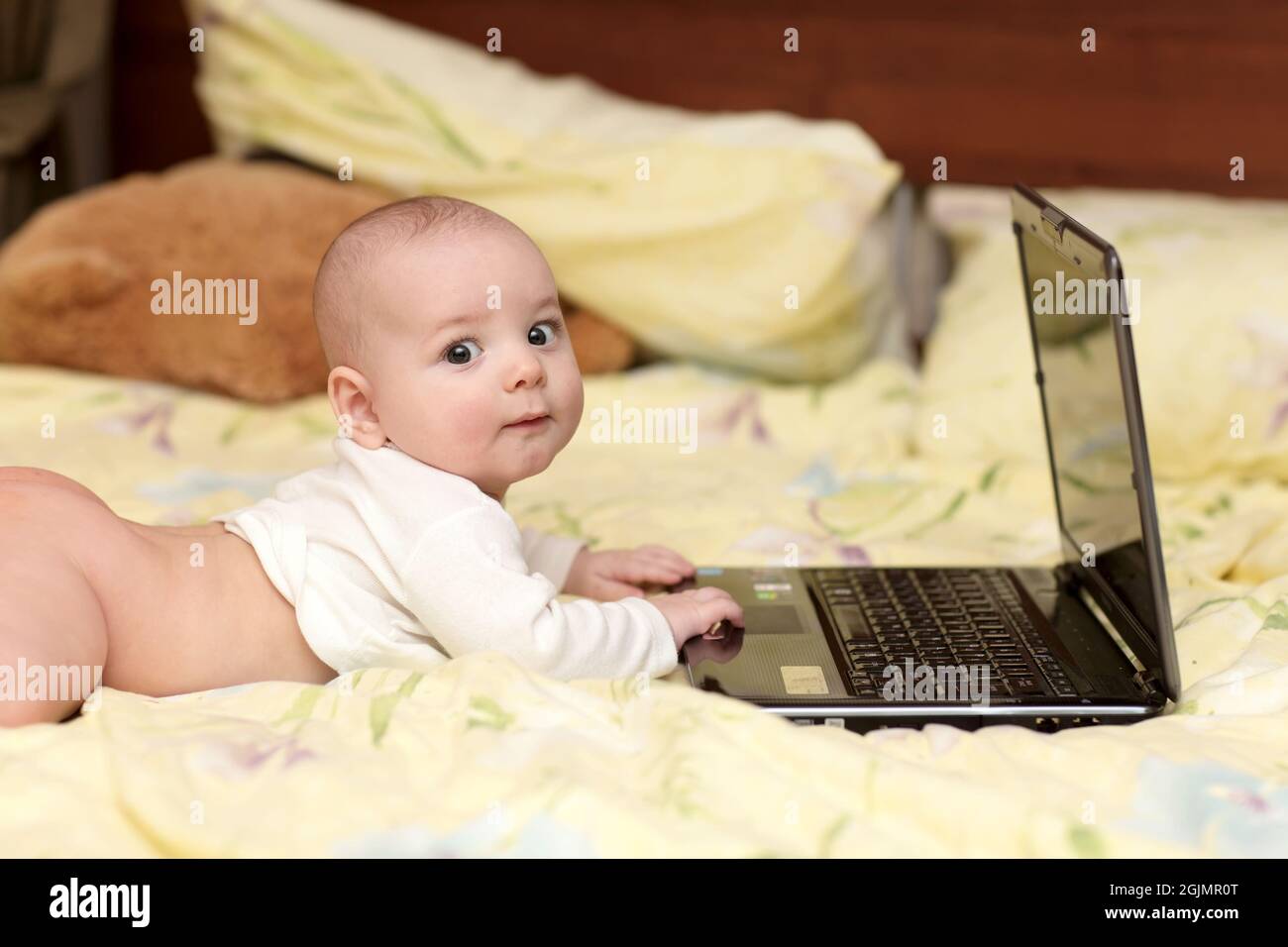 The little hacker is lying on a bed with laptop Stock Photo Alamy