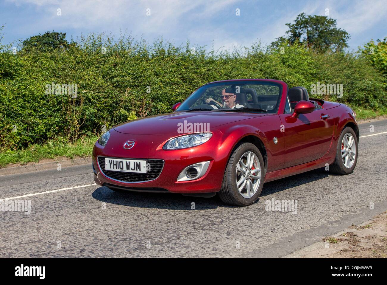 2010 red Mazda MX-5 i Roadster SE 1798cc petrol en-route to Capesthorne Hall classic July car show, Cheshire, UK Stock Photo