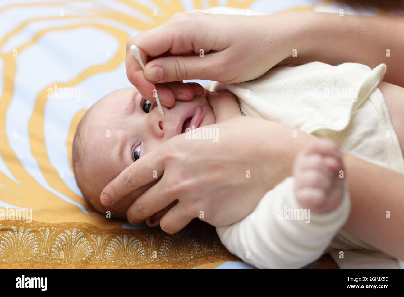 A mother cleaning baby nose by cotton swab after bath at home Stock Photo Alamy