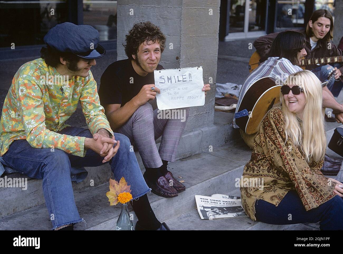 USA december 1968. Students at University of California Berkeley in typical 1968 clothes. The young man is holding an handwritten sign with the message: Smile!! There's a lot to be happy about!! 6-1-19 Credit Roland Palm ref 6-1-14 Stock Photo